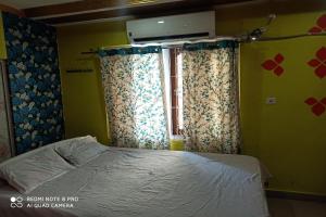 una camera con letto e finestra con tende di OYO Nirmal Guest House a Guwahati