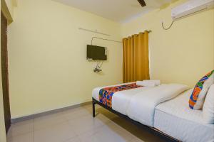 - une petite chambre avec un lit et une télévision dans l'établissement FabExpress Symphony Homes, Calangute Beach, à Vieux-Goa