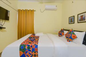 a bedroom with a bed with a colorful comforter at FabExpress Symphony Homes, Calangute Beach in Old Goa