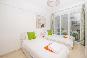 two beds in a white room with a window at Hillock Residence Apartments in Marsalforn