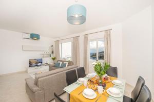 a living room with a table and a couch at Hillock Residence Apartments in Marsalforn