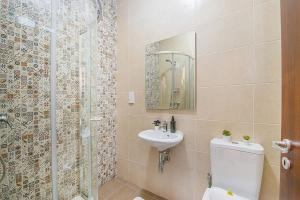 uma casa de banho com um chuveiro, um WC e um lavatório. em Hillock Residence Apartments em Marsalforn