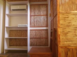 einen begehbaren Kleiderschrank mit Holztüren und Regalen in der Unterkunft Shiva's Hippies Colony in Sauraha