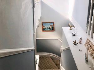 um corredor com escadas com aviões de brinquedo na parede em Coastal Hideaway em Sandown