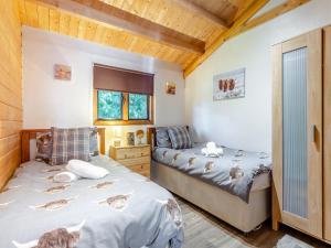 a bedroom with two beds in a room with wooden ceilings at The Willows in Glencoe