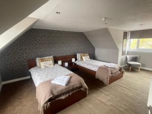 a attic room with two beds and a chair at Rooms at 31 in Stonehaven