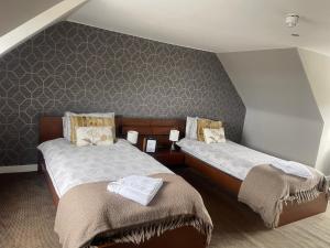 een slaapkamer met 2 bedden en een muur bij Rooms at 31 in Stonehaven