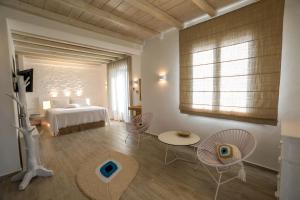 a bedroom with a bed and a table and chairs at Villa Elia by Mykonian Kazarte in Kalafatis +49 photos