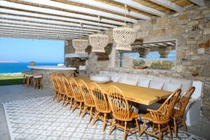 a dining room with a wooden table and chairs at Villa Elia by Mykonian Kazarte in Kalafatis