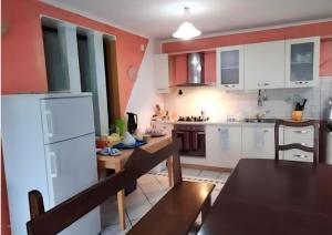 a kitchen with white cabinets and a dining table at Monti e Mare in Lanusei