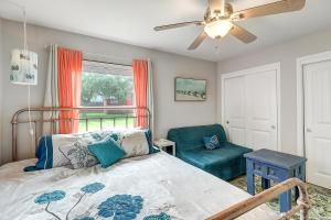 a bedroom with a bed and a chair and a ceiling fan at Jewel's Peace of Paradise in Rockport