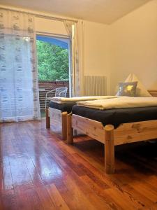 two beds in a room with a large window at ALPINpelso in Sankt Michael im Lungau