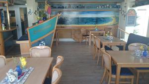 a restaurant with wooden tables and chairs and a counter at Landhotel Ostseetraum & Fewo in Warnemünde