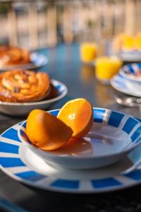 dos rebanadas de naranjas en platos sobre una mesa en La Grande Palmeraie - Spacieux studio avec vue mer, terrasse, port de Garavan, en Menton