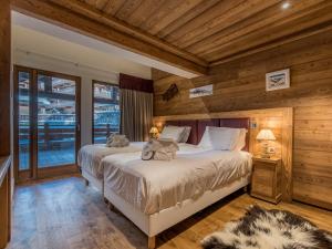 a bedroom with a large bed and wooden walls at Appartement de Luxe avec Cheminée, Jacuzzi et Hammam, Skis aux Pieds - Méribel - FR-1-613-84 in Les Allues