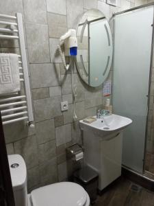 a bathroom with a toilet and a sink and a mirror at Epic Meidan Hotel in Tbilisi City