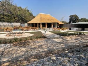 a hut with tables and chairs in front of it at Roma Guesthouse in the Heart of Lusaka in Lusaka