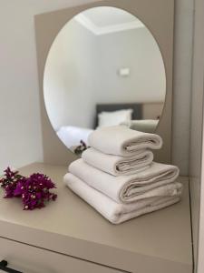 a stack of towels on a table in front of a mirror at Merve Apartments, your home from home in central BODRUM, street cats frequent the property, not all apartments have balconies , ground floor have terrace with table and chairs in Bodrum City