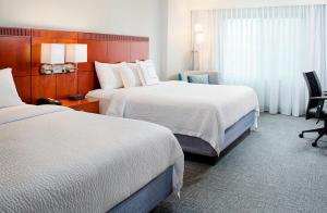 una camera d'albergo con due letti e una finestra di Courtyard by Marriott Roanoke Airport a Roanoke