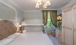 sypialnia z 2 łóżkami i żyrandolem w obiekcie Hotel Tahiti w Viareggio