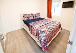 een slaapkamer met een bed met een dekbed en een raam bij Cozy Koreatown/Hollywood 2 Bedroom in Los Angeles