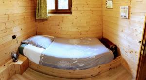 a small room with a bed in a log cabin at Studio Figues et Noix in Orchamps