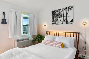 a bedroom with a bed with white sheets and a window at Waiakapuhi Studio suite.ʻoluʻolu pālua in Chandler