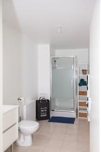 een badkamer met een douche, een toilet en een tas bij Echappée belle Osnyssoise in Osny
