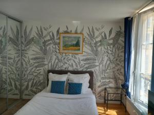 una camera da letto con un letto con cuscini blu e bianchi di Le Studio Versaillais a Versailles