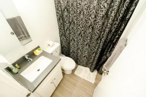 a bathroom with a sink and a toilet and a shower curtain at Cozy Koreatown/Hollywood 2 Bedroom in Los Angeles