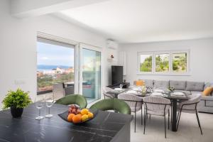 een eetkamer en een woonkamer met een tafel en stoelen bij Lucas - Sea view apartment with parking in Makarska