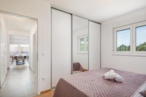 een slaapkamer met witte muren en een bed en ramen bij Lucas - Sea view apartment with parking in Makarska