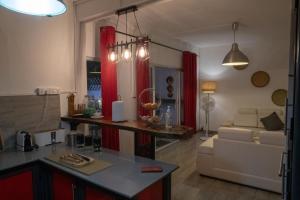 eine Küche und ein Wohnzimmer mit roten Vorhängen und einem Sofa in der Unterkunft Mathilde Villa Grand Baie in Grand Baie