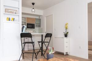 een keuken met een tafel en stoelen in een kamer bij Echappée belle Osnyssoise in Osny
