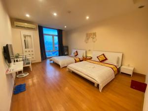 Großes Zimmer mit 2 Betten und einem TV. in der Unterkunft Phú Gia Hotel in Ho-Chi-Minh-Stadt