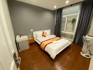 Habitación pequeña con cama y ventana en Phú Gia Hotel en Ho Chi Minh