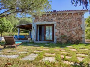 a stone house with a bench in front of it at Villa Valfrida in San Teodoro