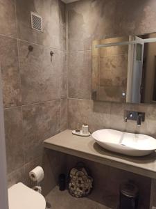 a bathroom with a sink and a mirror at Katerina's Maisonnette in Loutraki