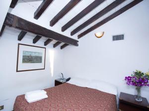 een slaapkamer met een rood bed en houten plafonds bij Hotel Residence Villa Tassoni in Rome +44 foto's