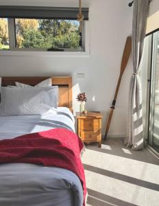 - une chambre avec un lit et une couverture rouge dans l'établissement Viola - Seaside Retreat, à Coles Bay