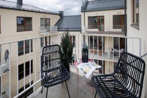 d'un balcon avec deux chaises et une table. dans l'établissement Leonardo Studio Apartments In City Center, à Riga