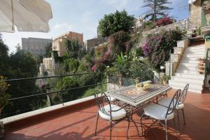 a patio with a table and chairs on a balcony at Casa Costa in Taormina