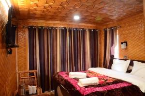 a bedroom with a bed with towels on it at Hotel Mughal India in Sonāmarg