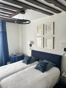 two beds in a room with blue and white at Hotel du Dragon in Paris