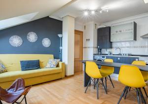 a living room with a yellow couch and a kitchen at Apartamento Irene céntrico con Wifi y parking coche tamaño medio Cangas de Onís in Cangas de Onís