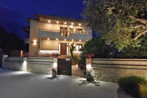 a house with lights on the front of it at Sinodinos Deluxe Apartments in Afitos