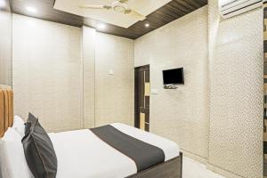 a bedroom with a bed and a tv on the wall at OYO Flagship 80575 Kashish Residency Near Model Town Metro Station in New Delhi