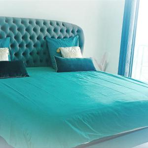 ein blaues Bett mit blauer Bettdecke und Kissen in der Unterkunft La VILLA MAHOT in Petite Île