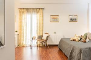 a bedroom with a bed and a chair and a table at Beautiful City Rooms close to Acropolis in Athens