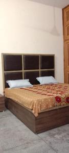 een slaapkamer met een bed met een houten frame bij SPOT ON 83131 Saini Property in Nārnaul